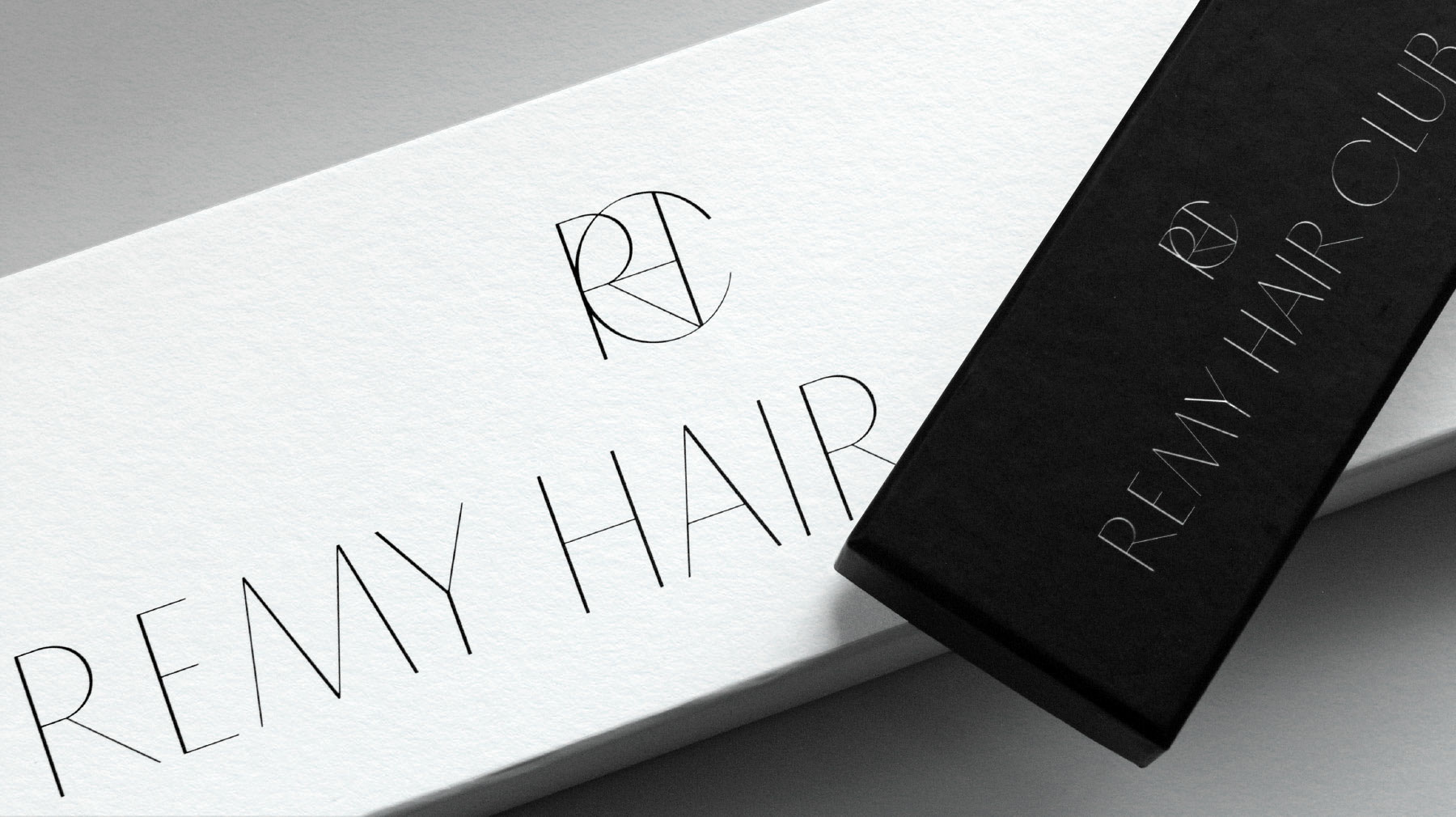 Black and white matte card packaging boxes with Remy Hair Club logotype